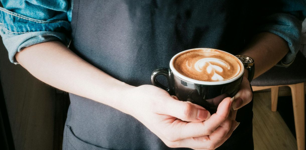 woman holding mug of cappuccino