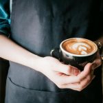 woman holding mug of cappuccino