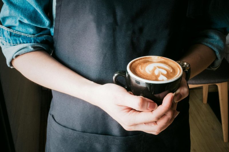 woman holding mug of cappuccino